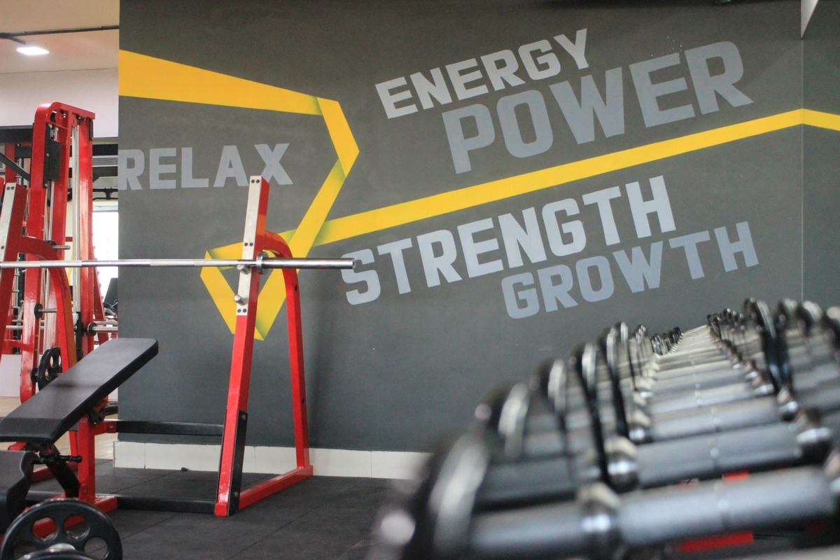 Incline Barbell Bench Press and Dumbbell Racks with Wall Typography