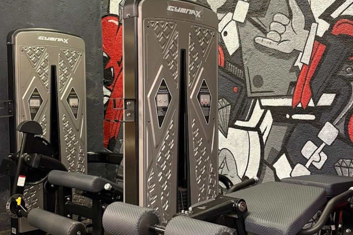 Selectorized Leg Extension and Curl Stations against Graffiti Feature Wall